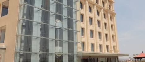 Ein Gebäude mit Glasfassade und einem Innenhof mit Außenbestuhlung.