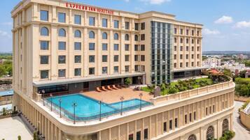 Un hotel con una piscina grande, varias plantas y un área de spa.