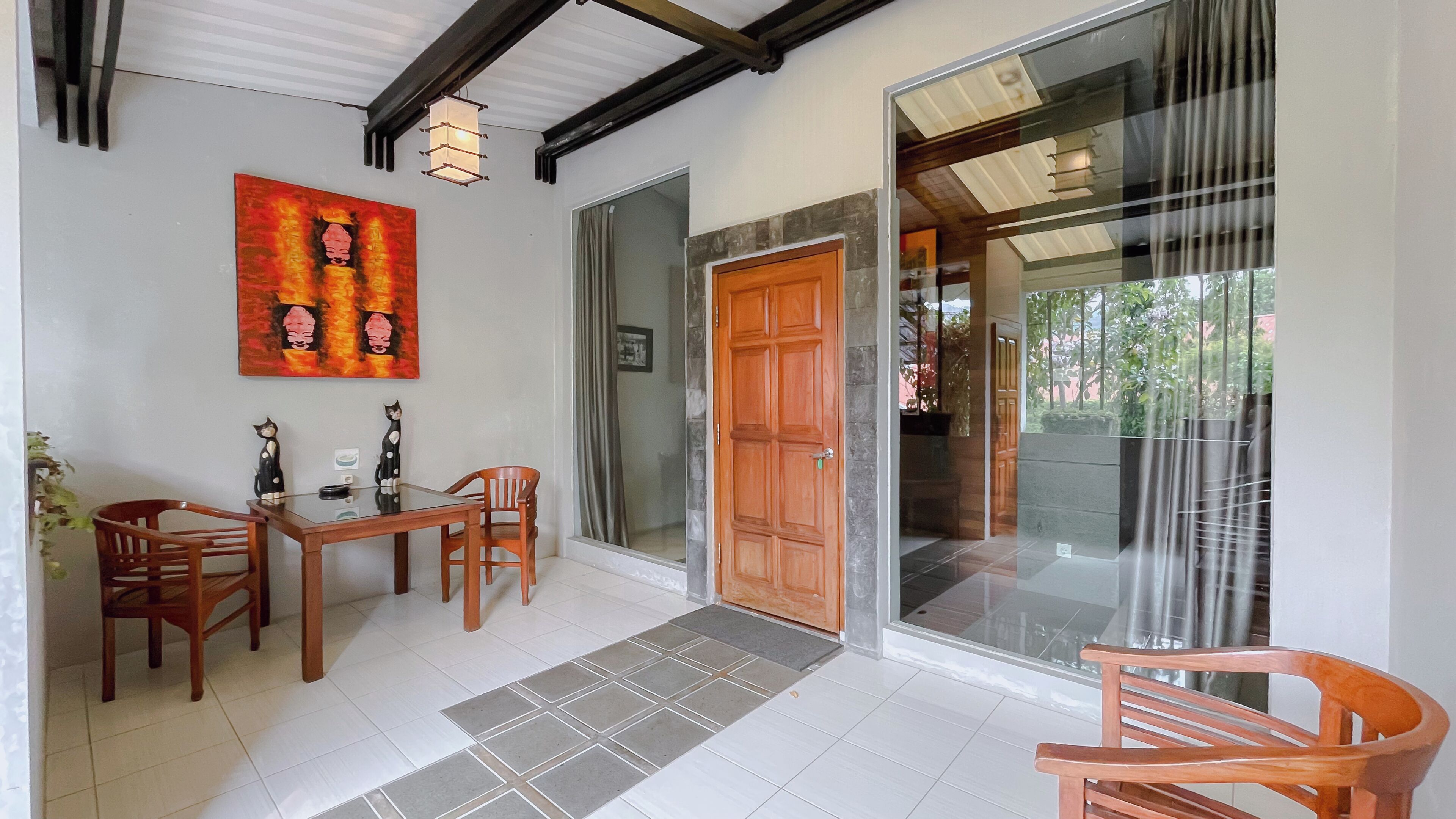 A dining area with a table, chairs, a wooden door, and a glass entrance.