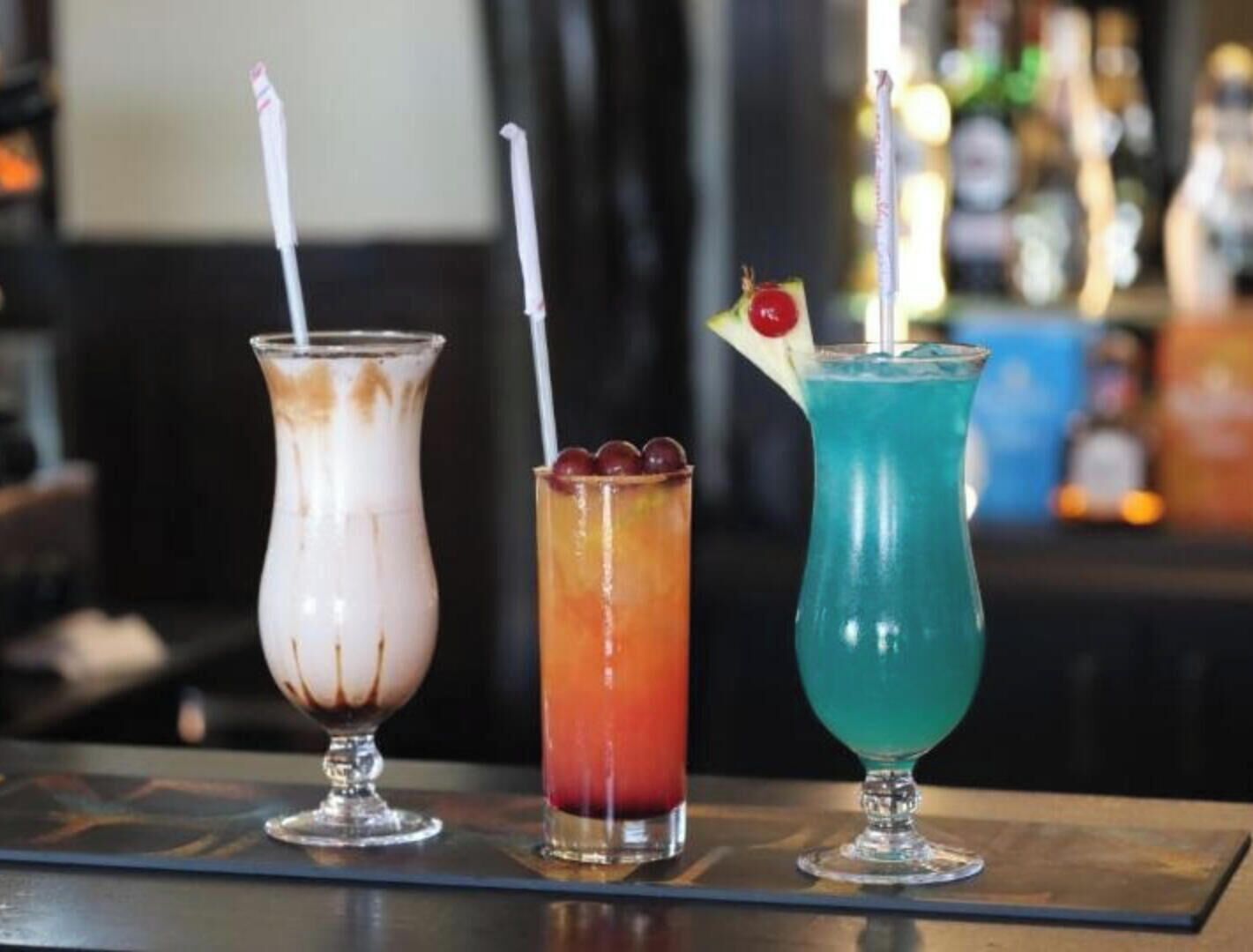 Tres bebidas sobre una barra.
