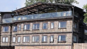 Un immeuble en bois à plusieurs étages, doté de balcons et de grandes fenêtres.