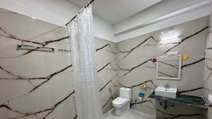 A bathroom with a shower curtain, a toilet, and a sink with a mirror.