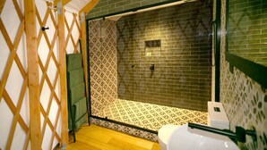 Un baño con ducha, paredes de azulejos y una estructura de madera enrejada.