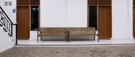 A room with two wooden doors, a bench, and a tiled floor.