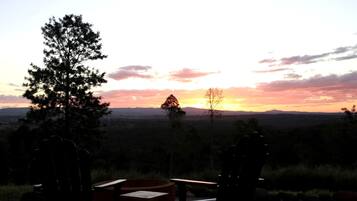 A sunset view with chairs and a table in a natural setting.