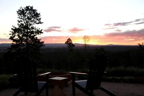 A sunset view with chairs and a table in a natural setting.