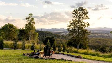 A scenic outdoor seating area with a table and chairs, surrounded by a natural landscape and trees.