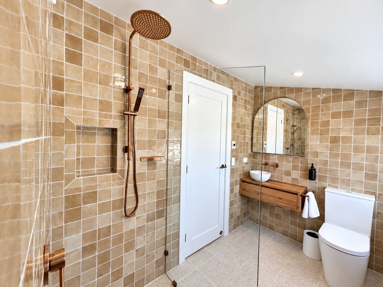 Une salle de bain équipée d’une douche, de toilettes, d’un lavabo et d’un miroir.