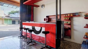 A bar area with stools, a counter, and shelves with bottled beverages.