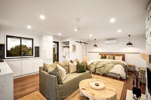 Un dormitorio moderno con cama, mesita de noche y un ventanal amplio.