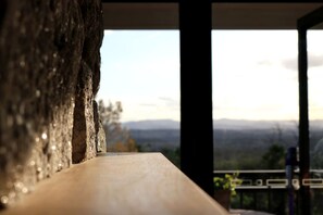 A wooden ledge with a view of a mountainous landscape.