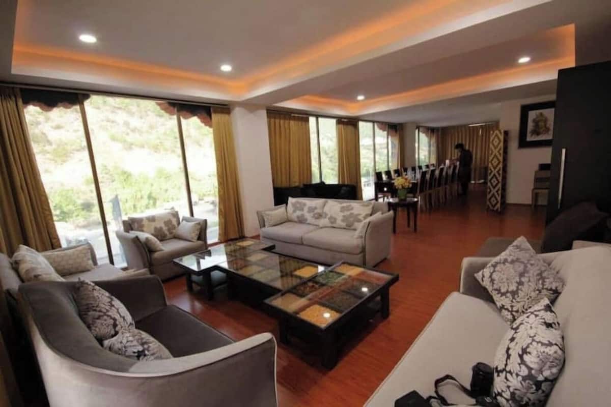 A spacious living room with a large coffee table, sofas, and a dining area with chairs.