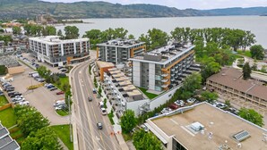 Ein moderner Gebäudekomplex mit mehreren Stockwerken, Parkplätzen und Seeblick.