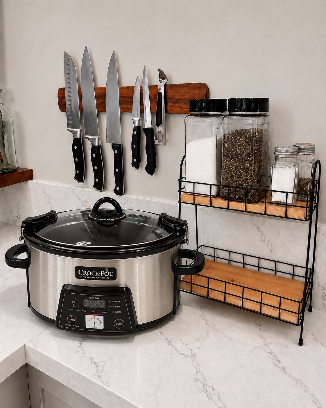 A kitchen with a slow cooker, a knife rack, and spice jars on shelves.