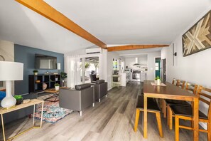 Uma sala de estar moderna com sofá, mesa de jantar e televisão.