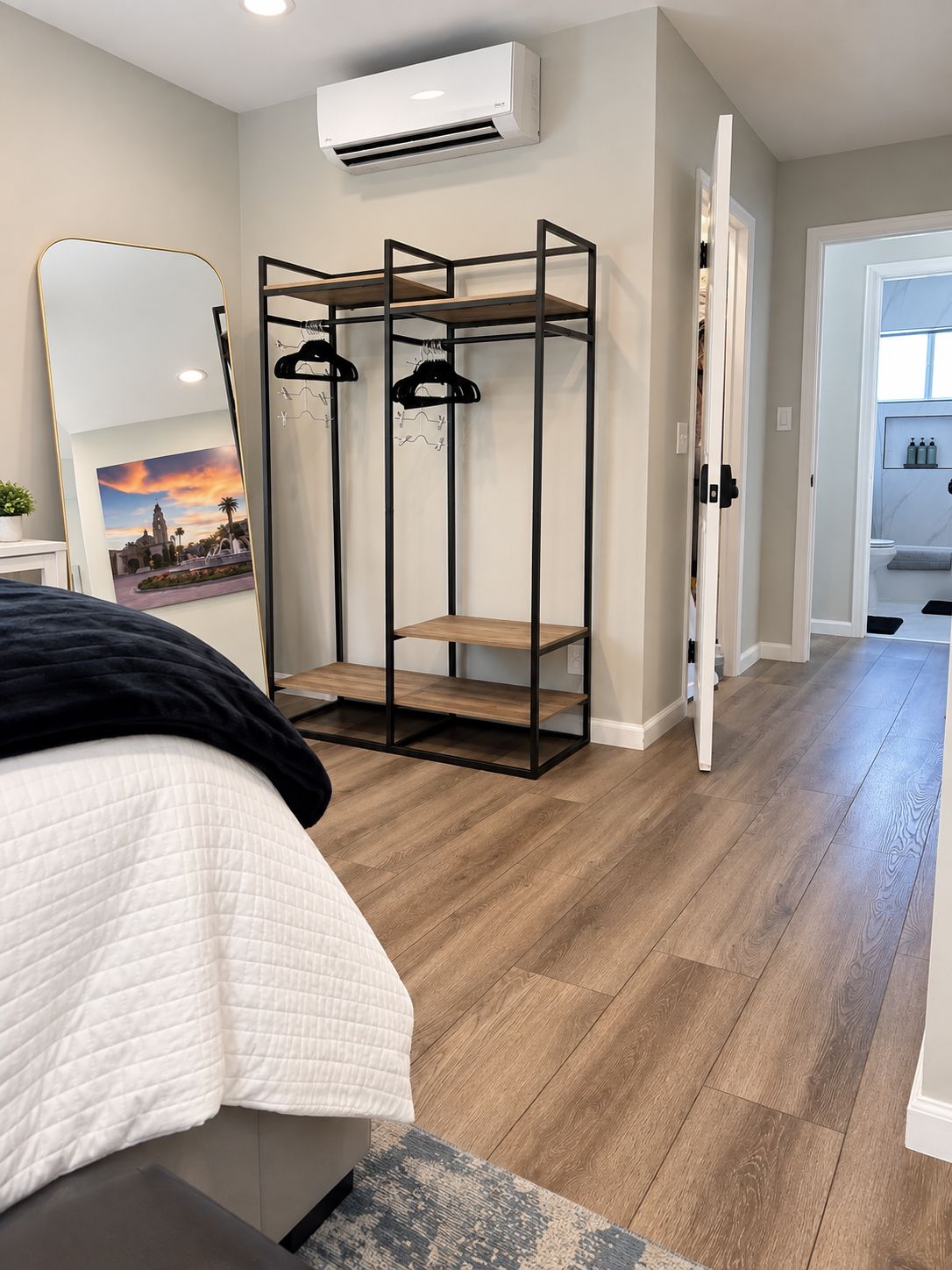 A bedroom with a bed, a wardrobe, and a bathroom visible through an open door.