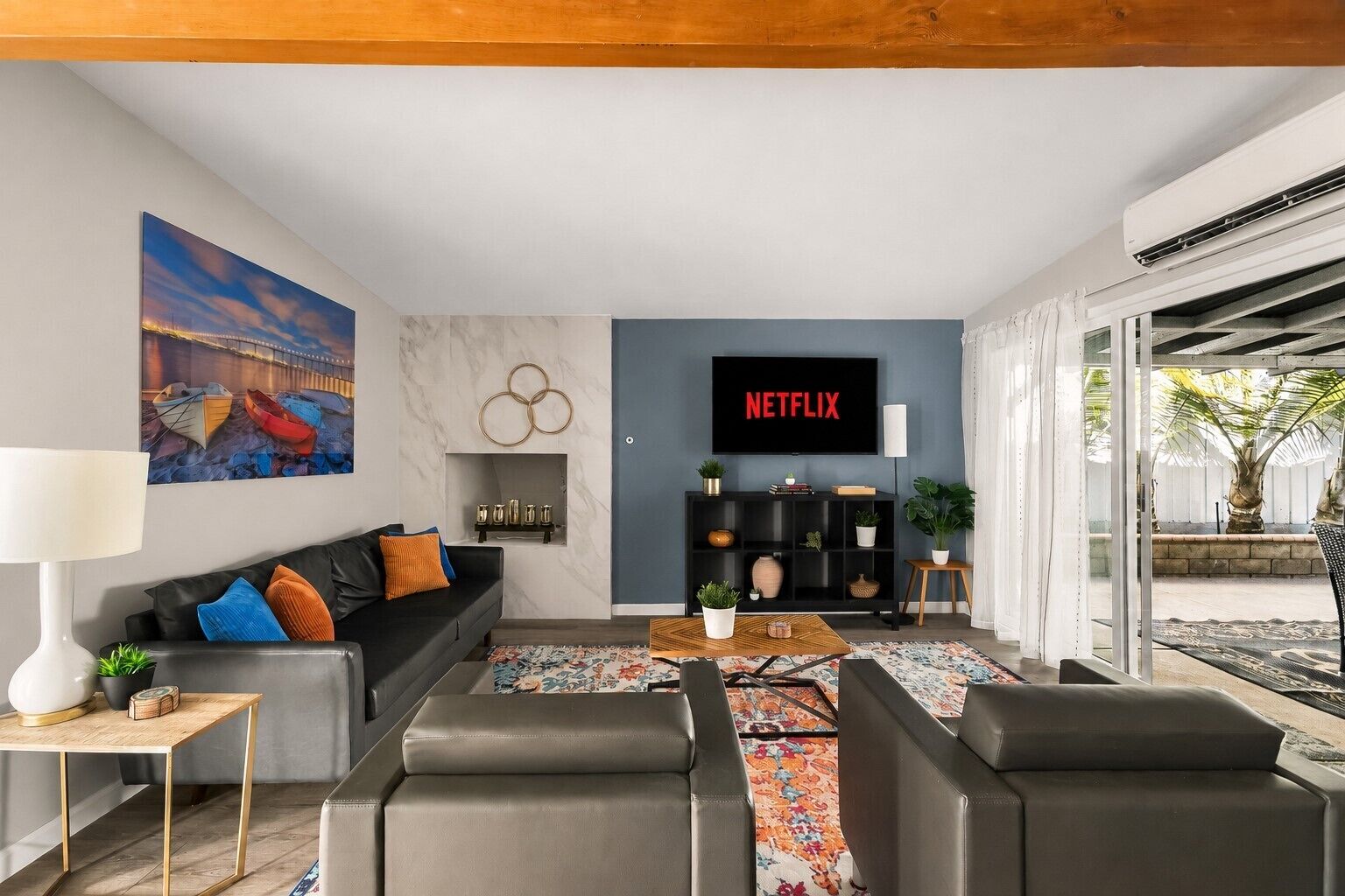 A modern living room with a sofa, coffee table, and a TV displaying 'NETFLIX'.