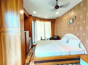 Un dormitorio con cama, una silla, un escritorio y un ventilador de techo.