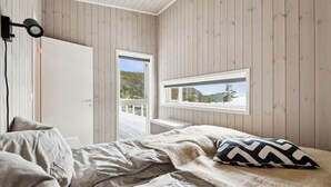 Un dormitorio con cama, ventana con vistas a un bosque y cámara instalada.