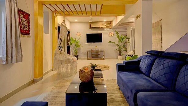 Una sala de estar moderna con un sofá azul, una mesa de centro y un televisor.