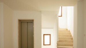 Un escalier menant à l’étage supérieur, une porte et une petite fenêtre.