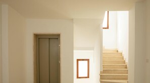 Eine Treppe, die zu einer oberen Etage führt, eine Tür und ein kleines Fenster.