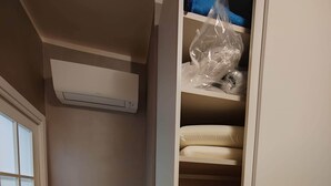 A walk-in closet with a bench, a bed, and a heater. - Gozzi's Den - Alghero (Alghero)