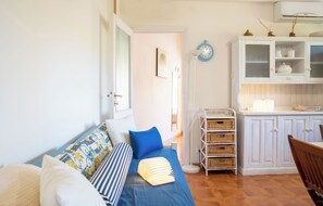 A cozy room with a bed, a dining table, and a kitchen area. - Alghero Sa Stella Holiday Home (Alghero)