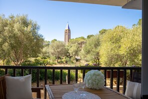 A balcony with a view of a tower, surrounded by greenery. - Alghero Sa Stella Holiday Home (Alghero)