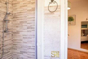 A bathroom with a shower, a towel ring, and a framed picture on the wall. - Alghero Sa Stella Holiday Home (Alghero)