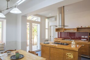 Eine moderne Küche mit Holzschränken, einer Kochinsel und einem großen Fenster für natürliches Licht.