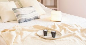 A bed with pillows, a bedside table with a lamp, and a tray with two cups. - Beyond the Port - Alghero (Alghero)