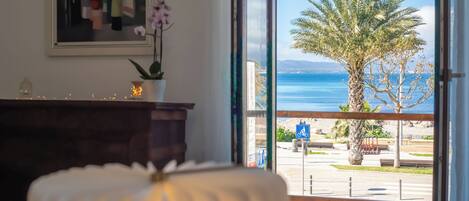 Una habitación con vista al mar, una planta en maceta y una obra de arte enmarcada en la pared.