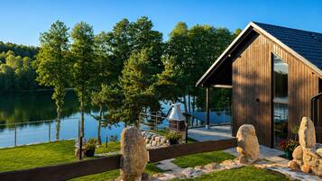 A cabin with a wooden exterior, a dock, and a stone fence.