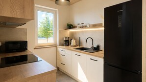 Una cocina moderna con un refrigerador negro, un microondas, una cafetera y un lavabo.