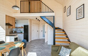 A compact kitchen with modern appliances, a dining area with a table and chairs, and a staircase leading to an upper level. - Cozy home in Lipnica with WiFi (Lipnica)