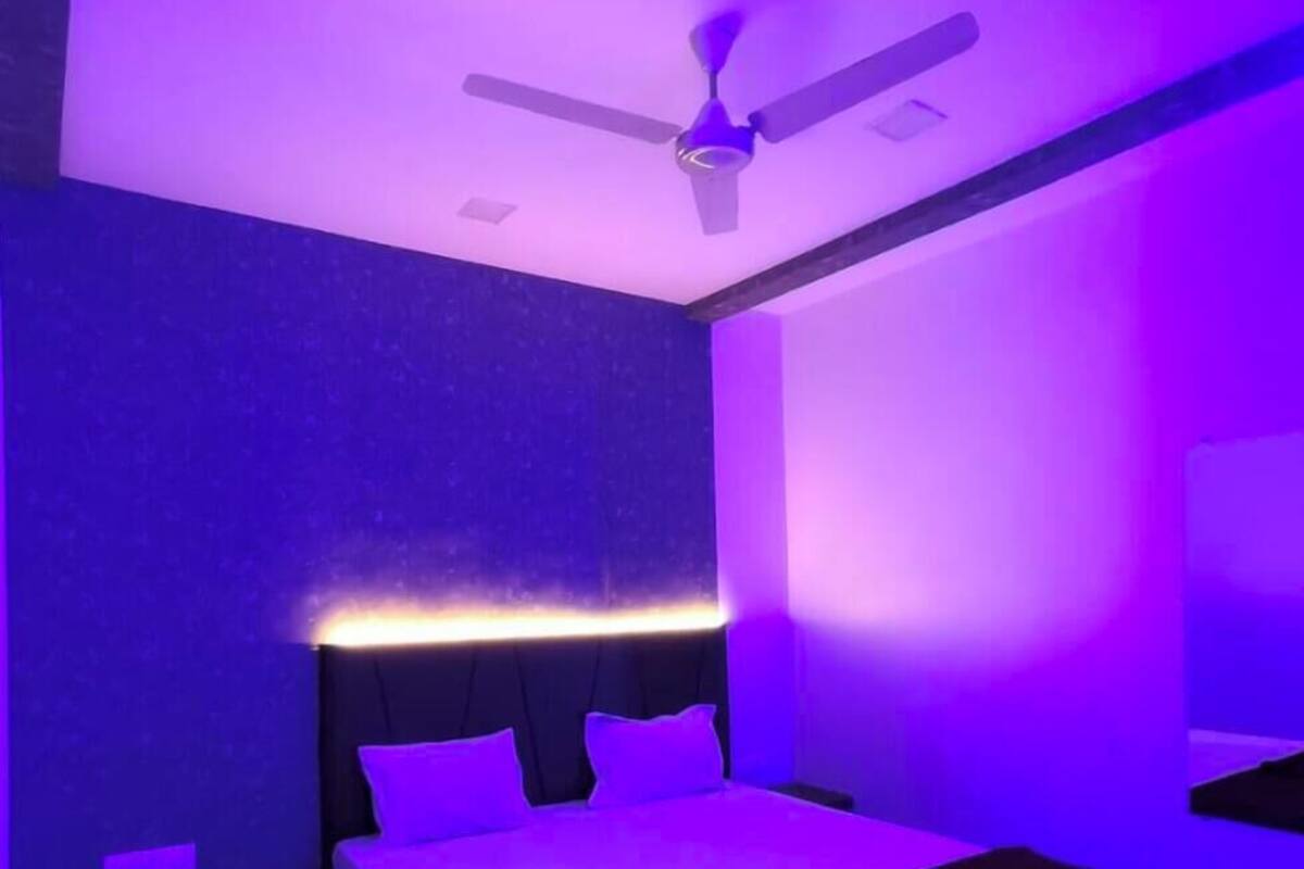 Un dormitorio con cama, ventilador de techo e iluminación empotrada en la pared.