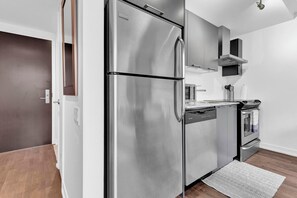 Eine moderne Küche mit Edelstahlgeräten, einem Geschirrspüler und einem Backofen.