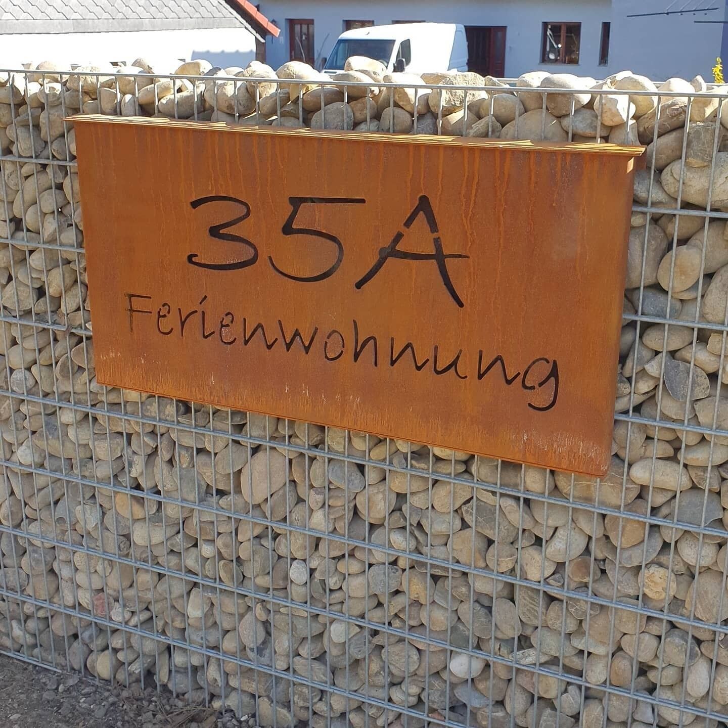 Señal de madera con la inscripción '35A' y 'Feriendorf', indicando una ubicación de alojamiento.