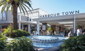 Ein Hotel am Wasserufer mit Pool, Palmen und einem Schild mit der Aufschrift 'Harbour Town'.