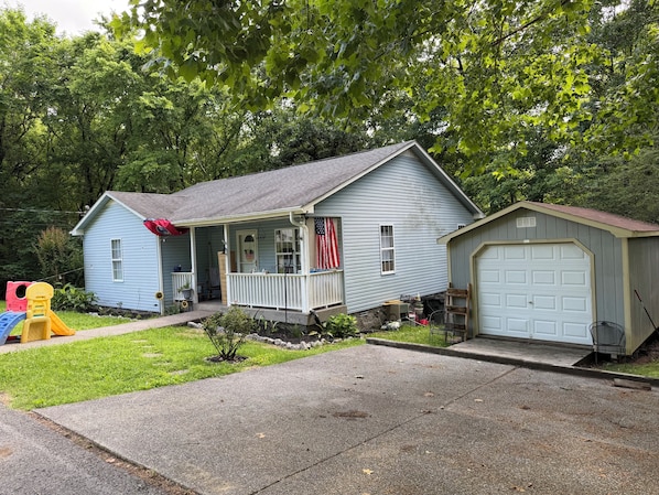 A residential house with a porch, a garage, and a children's playset.