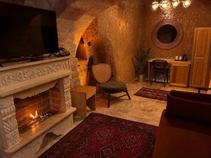 A cozy interior with a fireplace, seating area, and a television. - Honey of Cappadocia (Ürgüp)