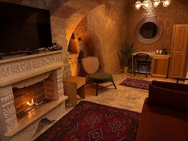 A cozy interior with a fireplace, seating area, and a television.