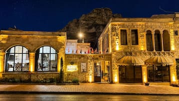 Un edificio histórico con ventanas arqueadas, una entrada central y un letrero que dice 'Honey Hotel'.