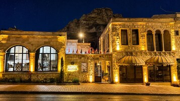Un edificio histórico con ventanas arqueadas, una entrada central y un letrero que dice 'Honey Hotel'.
