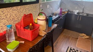 Cocina compacta con fregadero, estufa y ventana con vistas a zonas verdes.