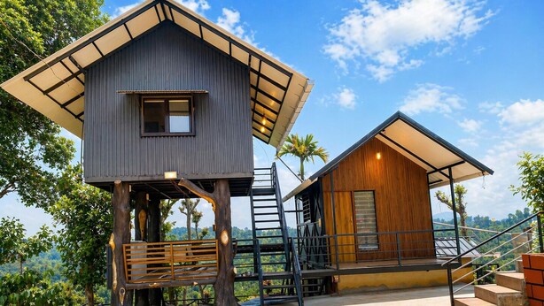 Una casa del árbol moderna con terraza de madera y una escalera.
