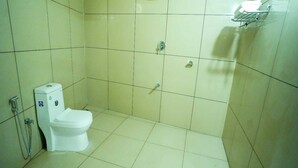Un baño pequeño y limpio con inodoro, ducha y toallero.