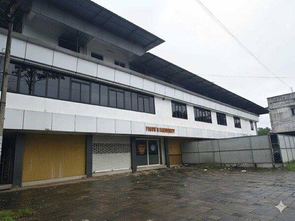 Un edificio de dos pisos con escaparate que dice 'Store & Kitchen'.