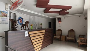 Un mostrador de recepción con detalles de madera, un ventilador y un reloj en la pared.
